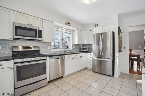 a kitchen with granite countertop cabinets stainless steel appliances and a counter space