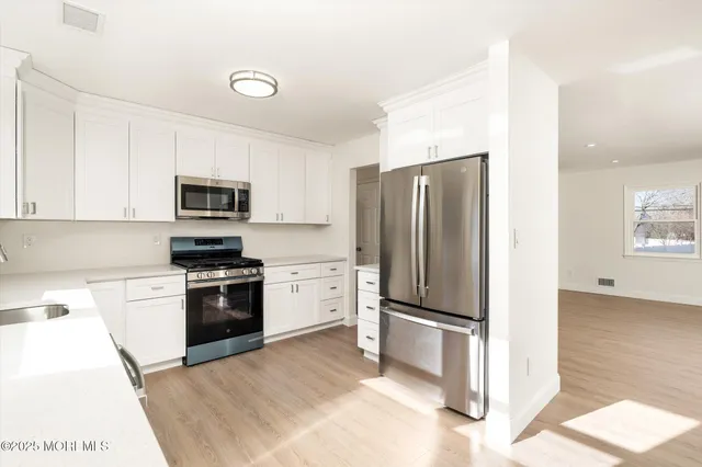 a kitchen with stainless steel appliances granite countertop a refrigerator stove and microwave