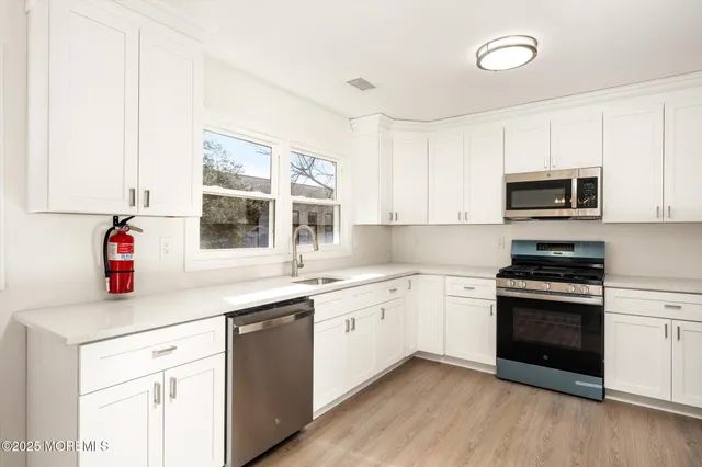 a kitchen with granite countertop white cabinets and white appliances