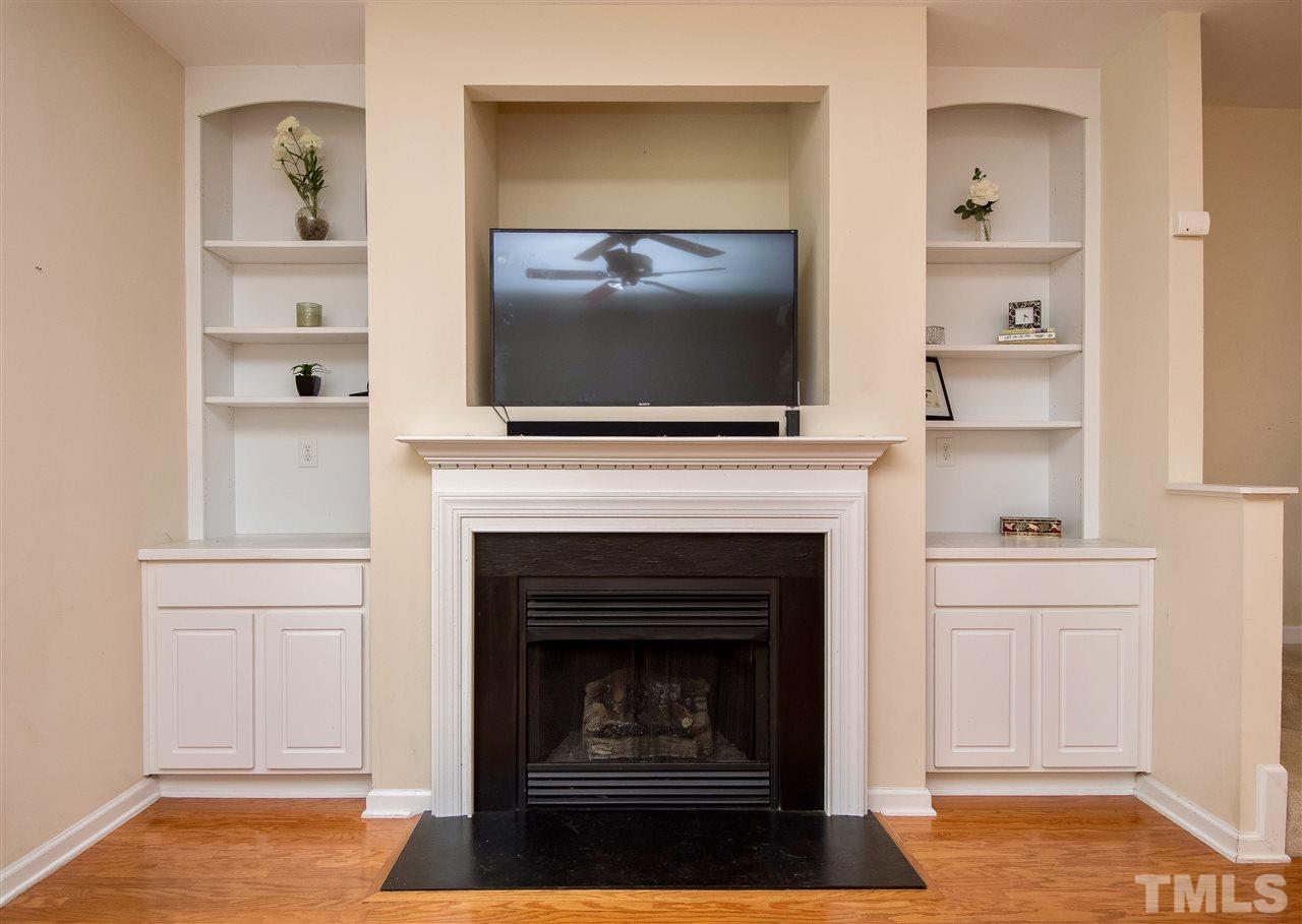 2135 Metacomet Way Raleigh, NC 27604 - Photo 7 of 25 a living room with a fireplace and a flat screen tv