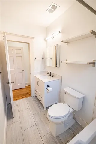 an empty room with wooden floor and fan