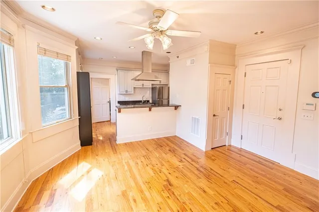 a view of a kitchen with wooden floor and a ceiling fan
