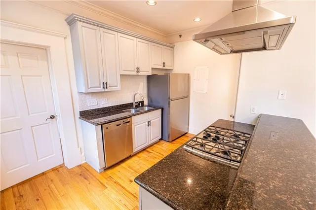 a kitchen with stainless steel appliances granite countertop a sink stove and refrigerator
