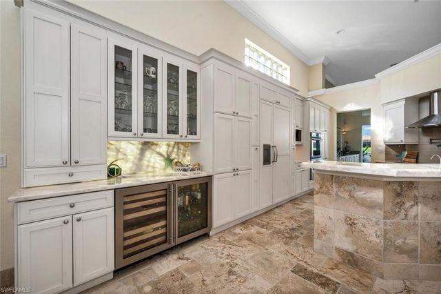 a large white kitchen with granite countertop a sink