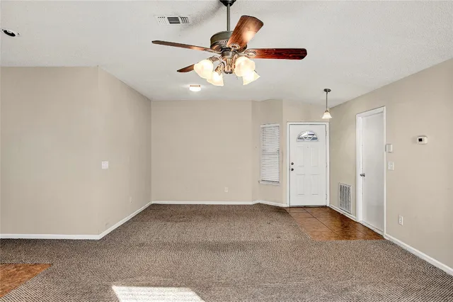wooden floor in an empty room and a chandelier fan