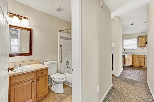 a bathroom with a granite countertop toilet a sink and a mirror