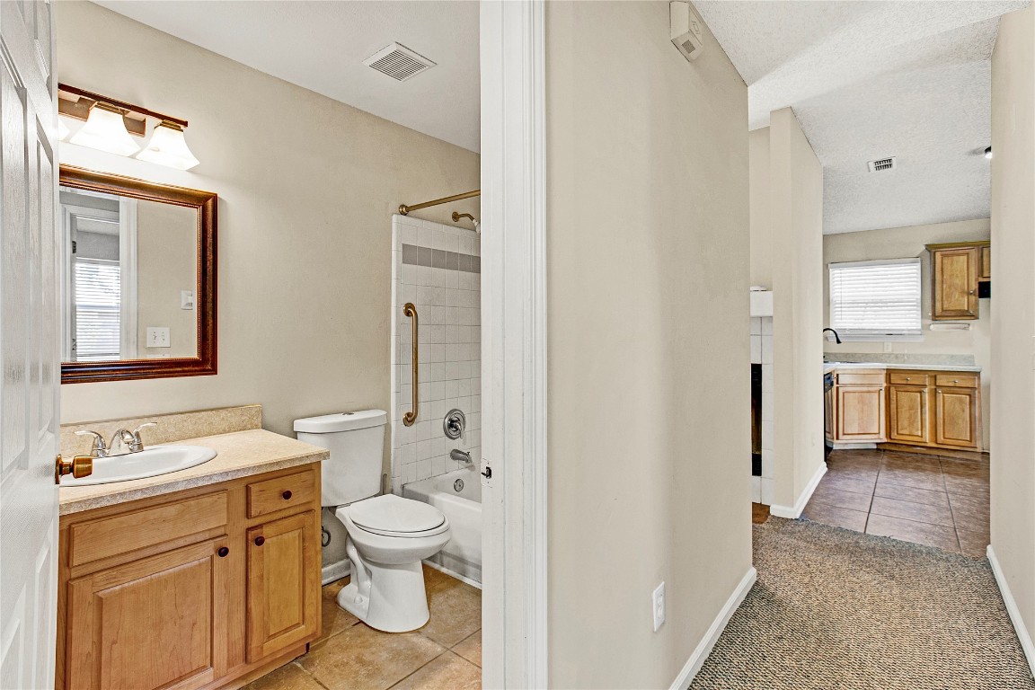 909 Gavagan Road Jacksonville, FL 32233 - Photo 6 of 17 a bathroom with a granite countertop toilet a sink and a mirror