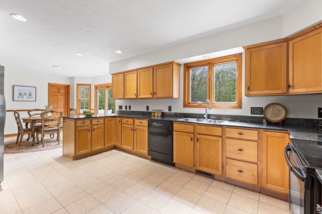 3 Wildflower Drive Sutton, MA 01590 - Photo 8 of 31 a kitchen with stainless steel appliances granite countertop a stove top oven a sink a dining table and chairs