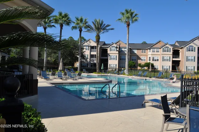 a view of a house with pool and sitting area