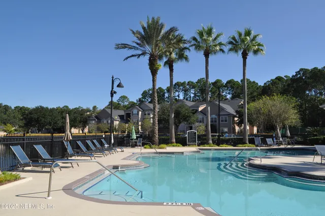 a view of swimming pool with table and chairs