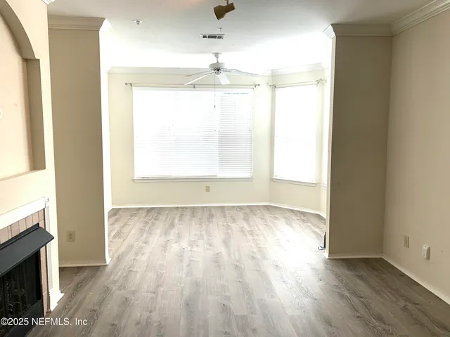 an empty room with wooden floor and windows