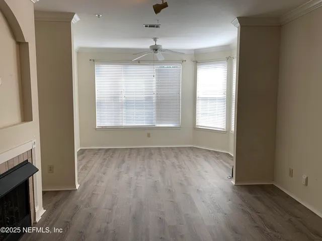 an empty room with wooden floor and windows