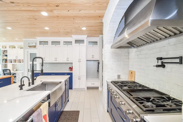 a kitchen with stainless steel appliances granite countertop a sink stove and cabinets