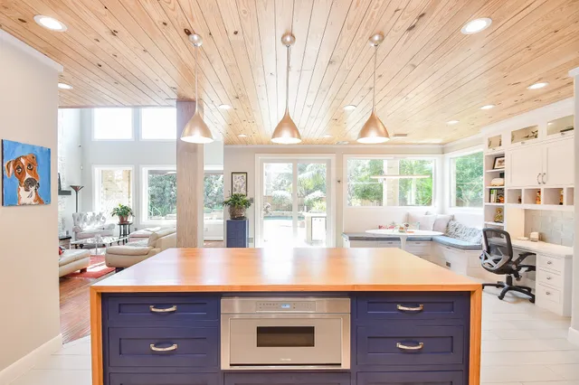 a kitchen with a sink and large windows
