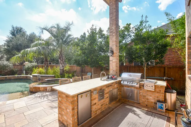 a view of a patio with a dining table and chairs with a small yard