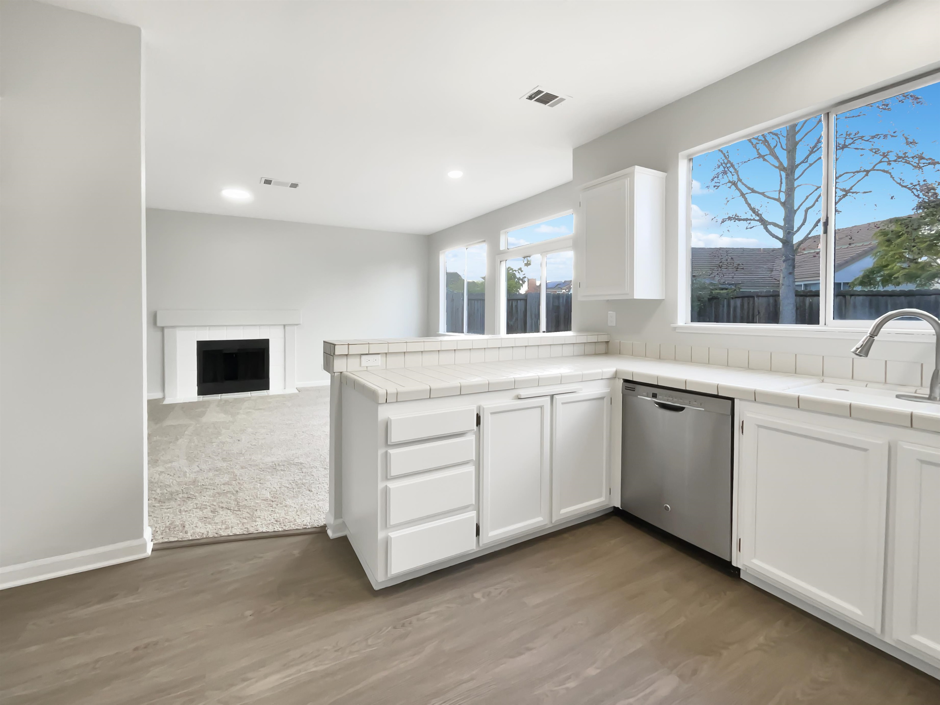 1474 Rutherford Lane Oakley, CA 94561 - Photo 11 of 31 Kitchen featuring tile countertops, white cabinetry, a peninsula, stainless steel dishwasher, and recessed lighting
