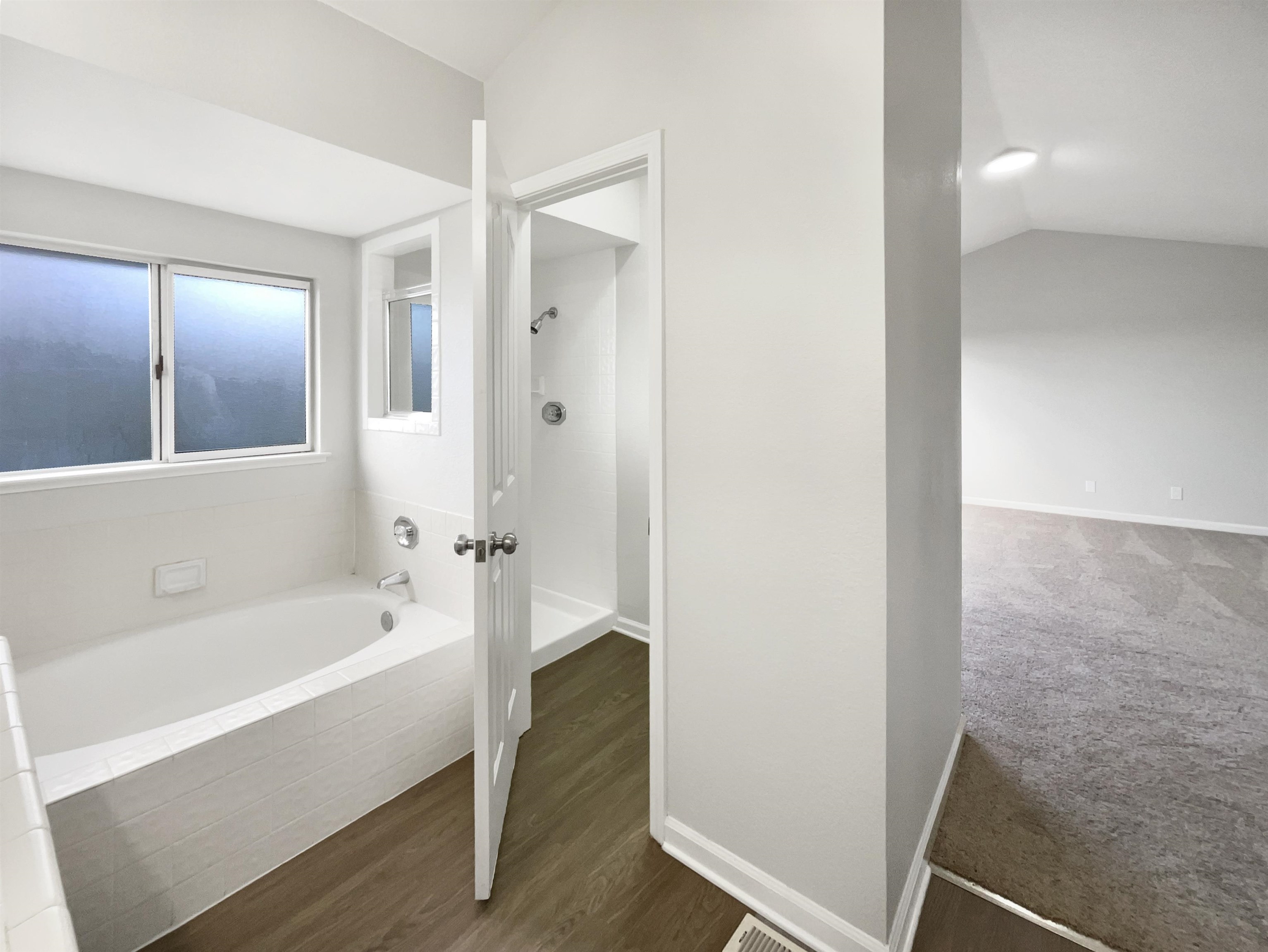 1474 Rutherford Lane Oakley, CA 94561 - Photo 27 of 31 Bathroom featuring a bath, vaulted ceiling, and dark wood-style floors