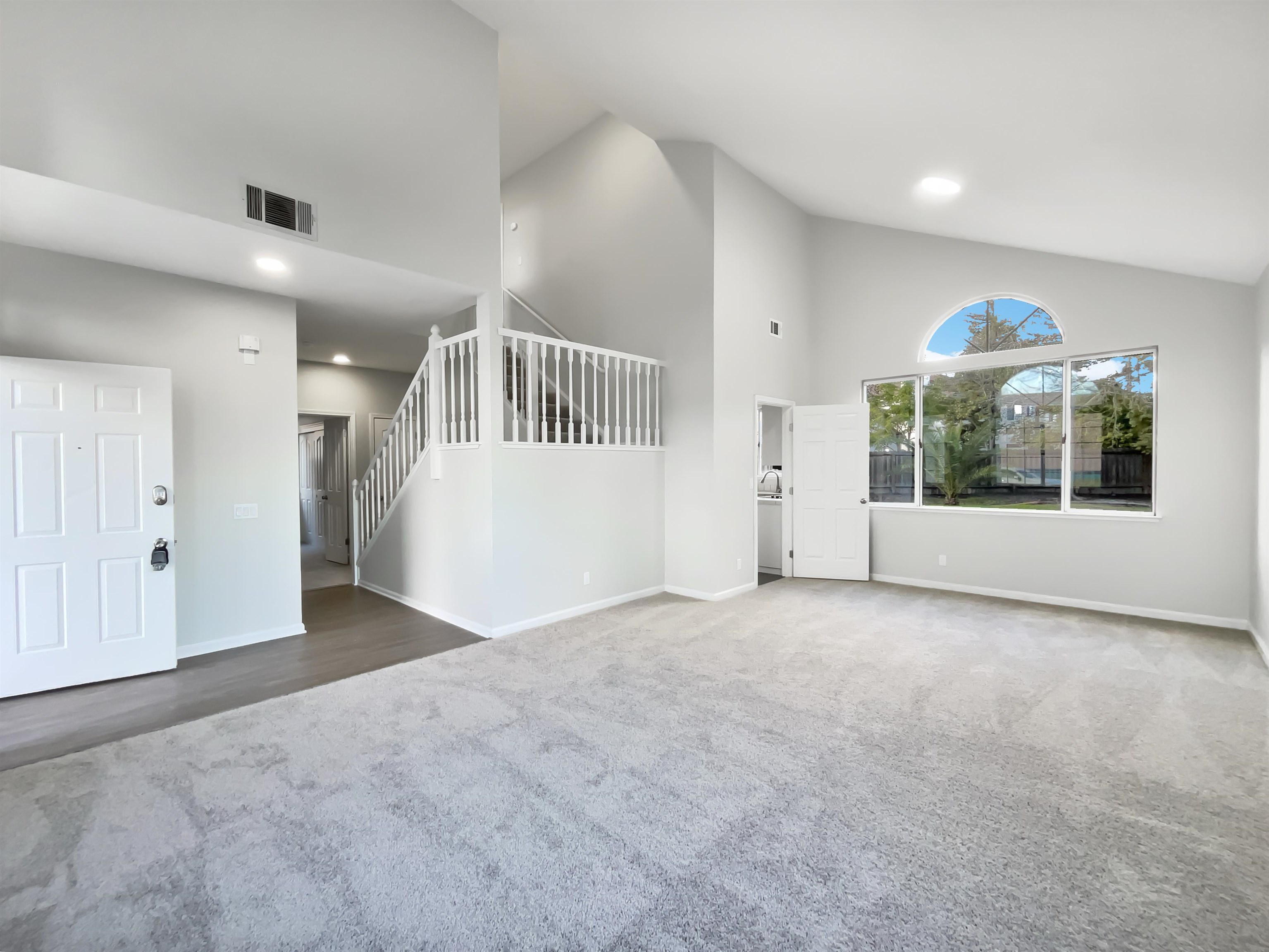 1474 Rutherford Lane Oakley, CA 94561 - Photo 9 of 31 Unfurnished living room with carpet, lofted ceiling, and recessed lighting