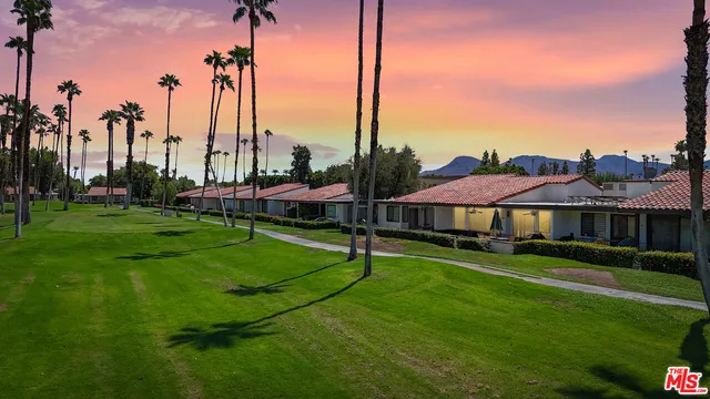 a view of a house with a yard and sitting area