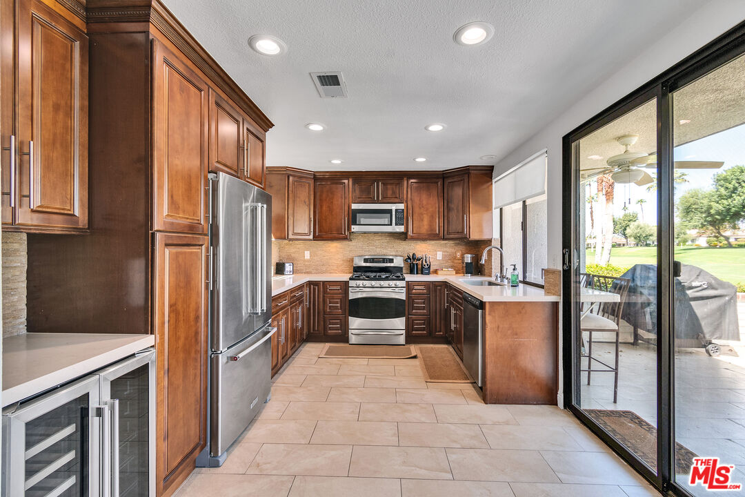 109 Torremolinos Drive Rancho Mirage, CA 92270 - Photo 25 of 39 a kitchen with stainless steel appliances granite countertop a refrigerator and a stove top oven