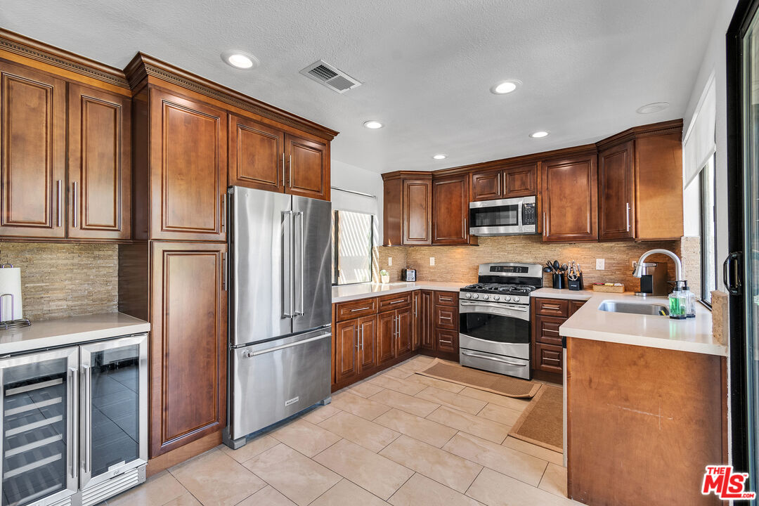 109 Torremolinos Drive Rancho Mirage, CA 92270 - Photo 27 of 39 a kitchen with granite countertop stainless steel appliances and wooden cabinets