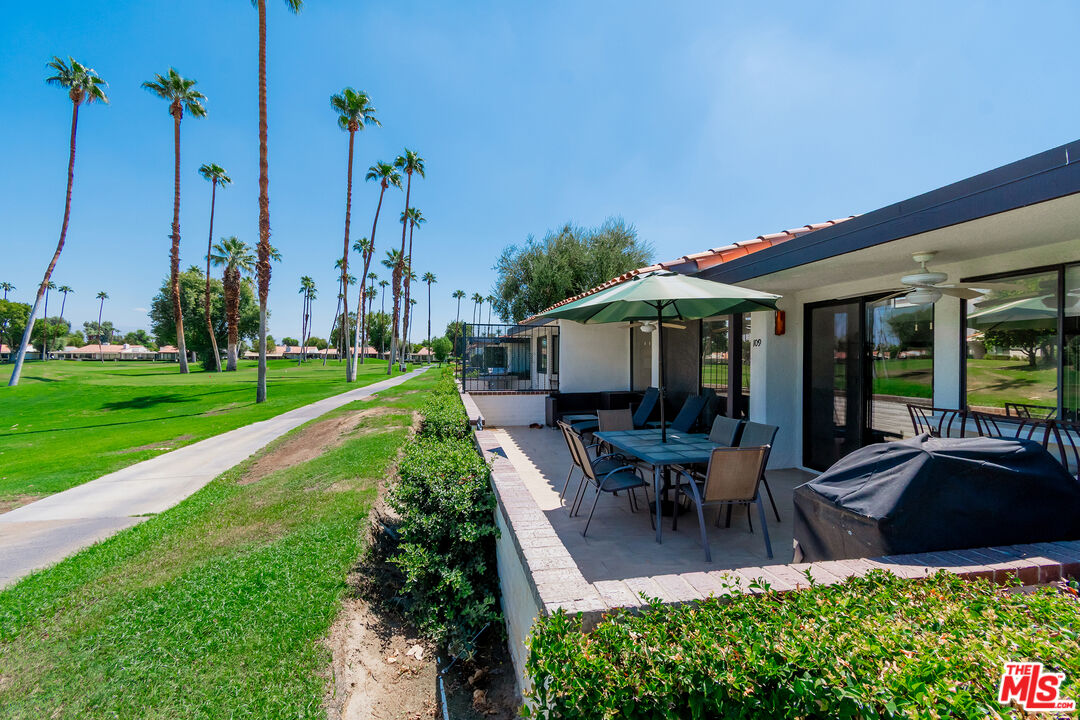 109 Torremolinos Drive Rancho Mirage, CA 92270 - Photo 32 of 39 a view of a patio with table and chairs potted plants and palm trees