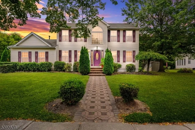 a front view of a house with yard and green space