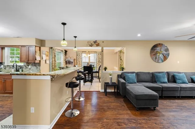 a living room with furniture kitchen view and a wooden floor