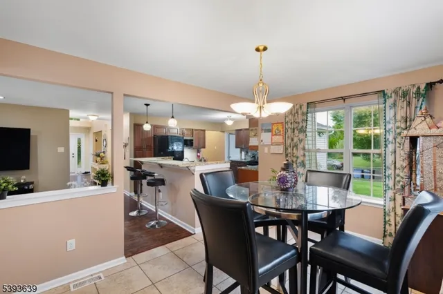 a dining room with furniture a chandelier and window