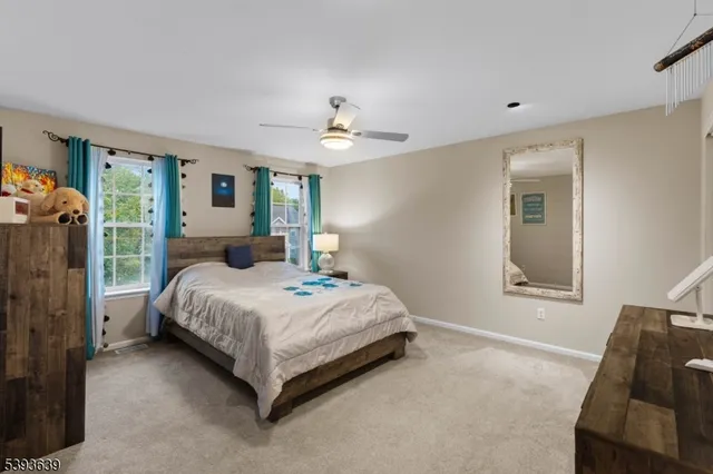 a bedroom with a large bed chandelier and a window