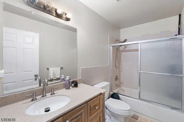 a bathroom with a sink toilet vanity and shower