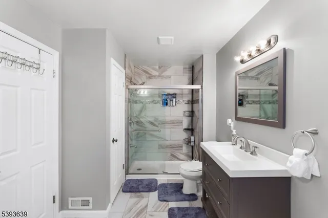 a bathroom with a sink toilet a mirror and shower