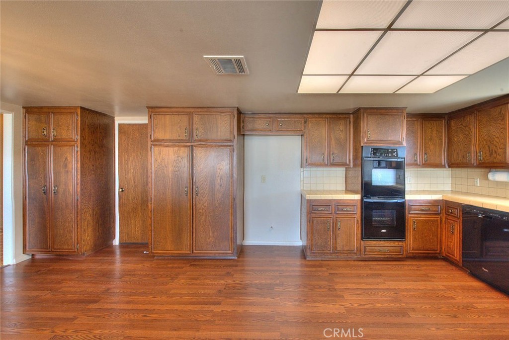 16464 Rancho Escondido Drive Riverside, CA 92506 - Photo 14 of 47 an empty room with wooden floor cabinet and windows