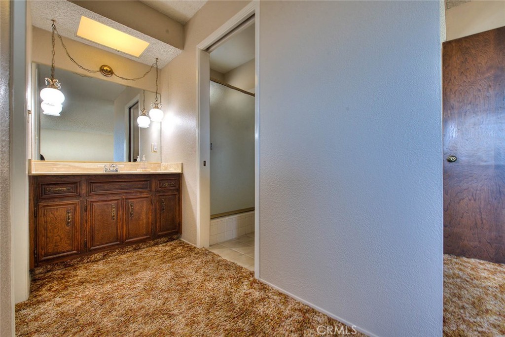 16464 Rancho Escondido Drive Riverside, CA 92506 - Photo 22 of 47 a bathroom with a granite countertop sink and a mirror
