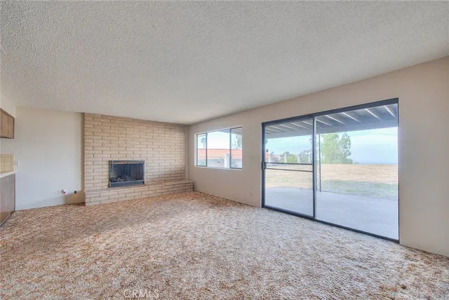 an empty room with windows and fireplace