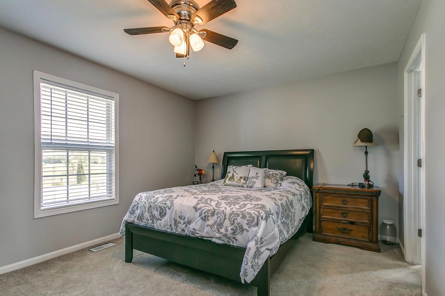 410 Jackson Road Portland, TN 37148 - Photo 9 of 22 a bedroom with a bed and a chandelier