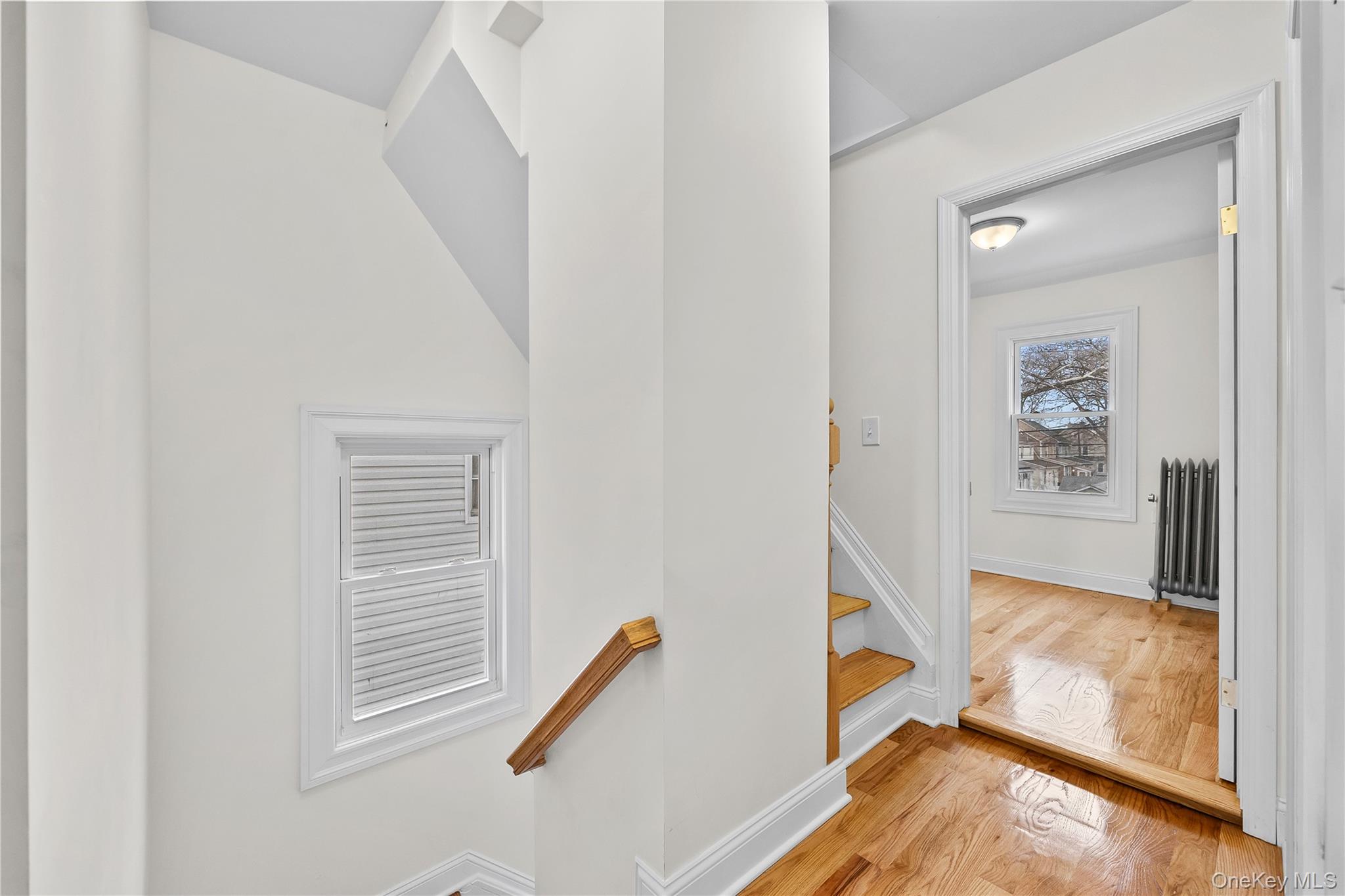 115-12 197th Street Queens, NY 11412 - Photo 13 of 26 Staircase with wood finished floors and radiator heating unit