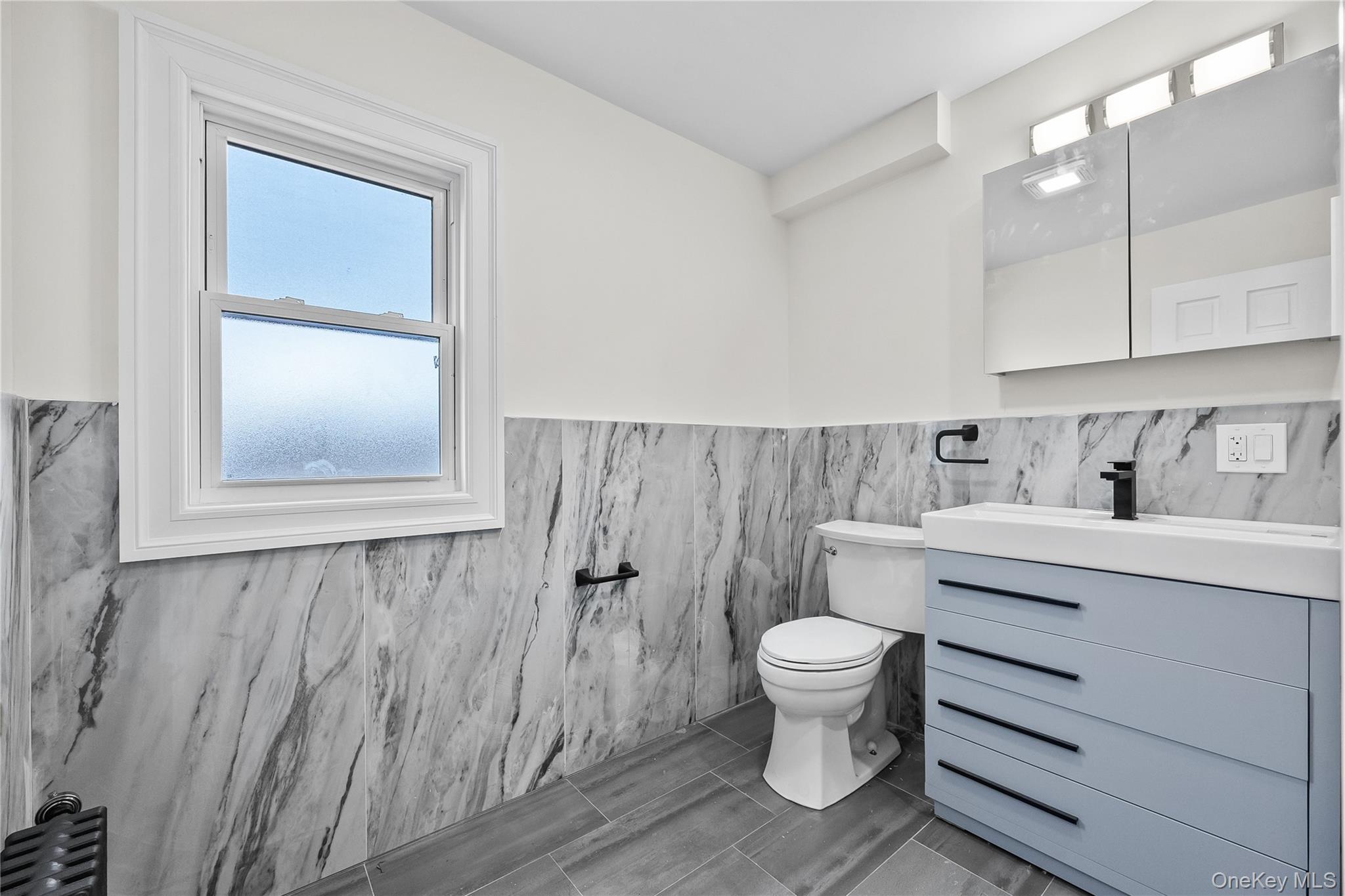115-12 197th Street Queens, NY 11412 - Photo 14 of 26 a bathroom with a toilet sink and mirror