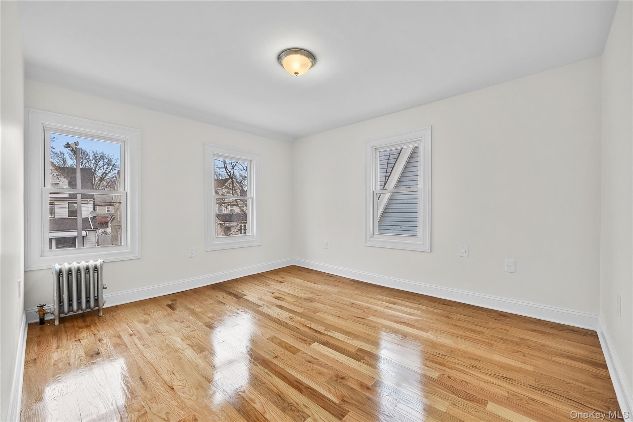 115-12 197th Street Queens, NY 11412 - Photo 16 of 26 a view of an empty room with wooden floor and a window