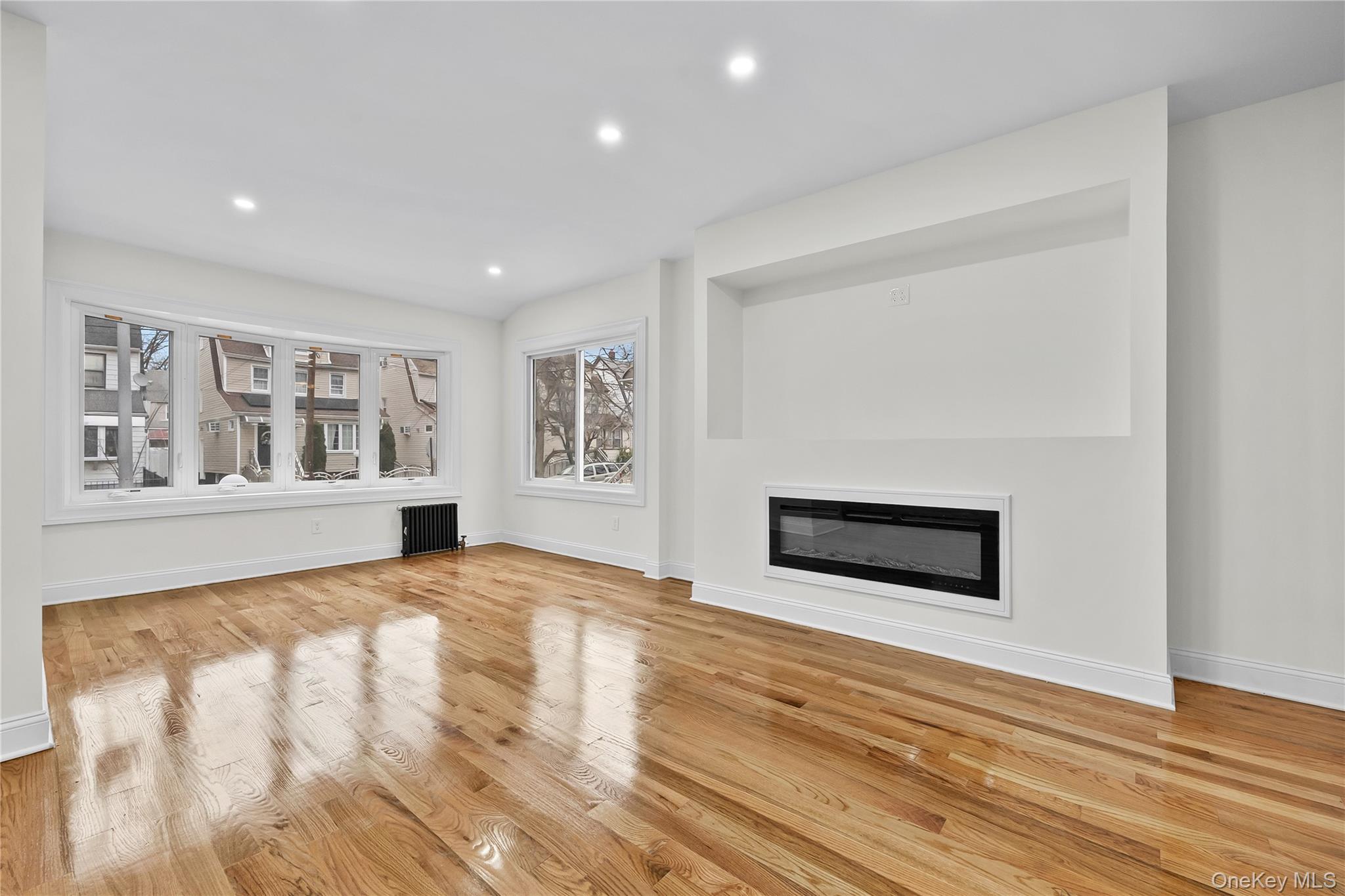 115-12 197th Street Queens, NY 11412 - Photo 4 of 26 a view of an empty room with window and fireplace