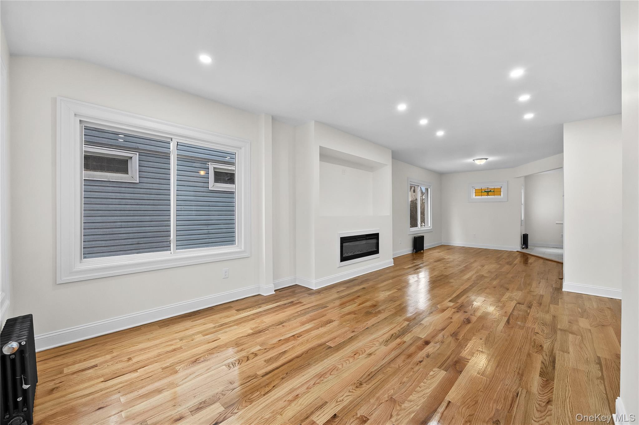 115-12 197th Street Queens, NY 11412 - Photo 6 of 26 a view of empty room with wooden floor and window
