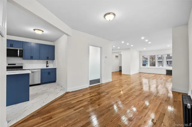 a large kitchen with kitchen island a sink dishwasher a stove and a refrigerator with wooden floor