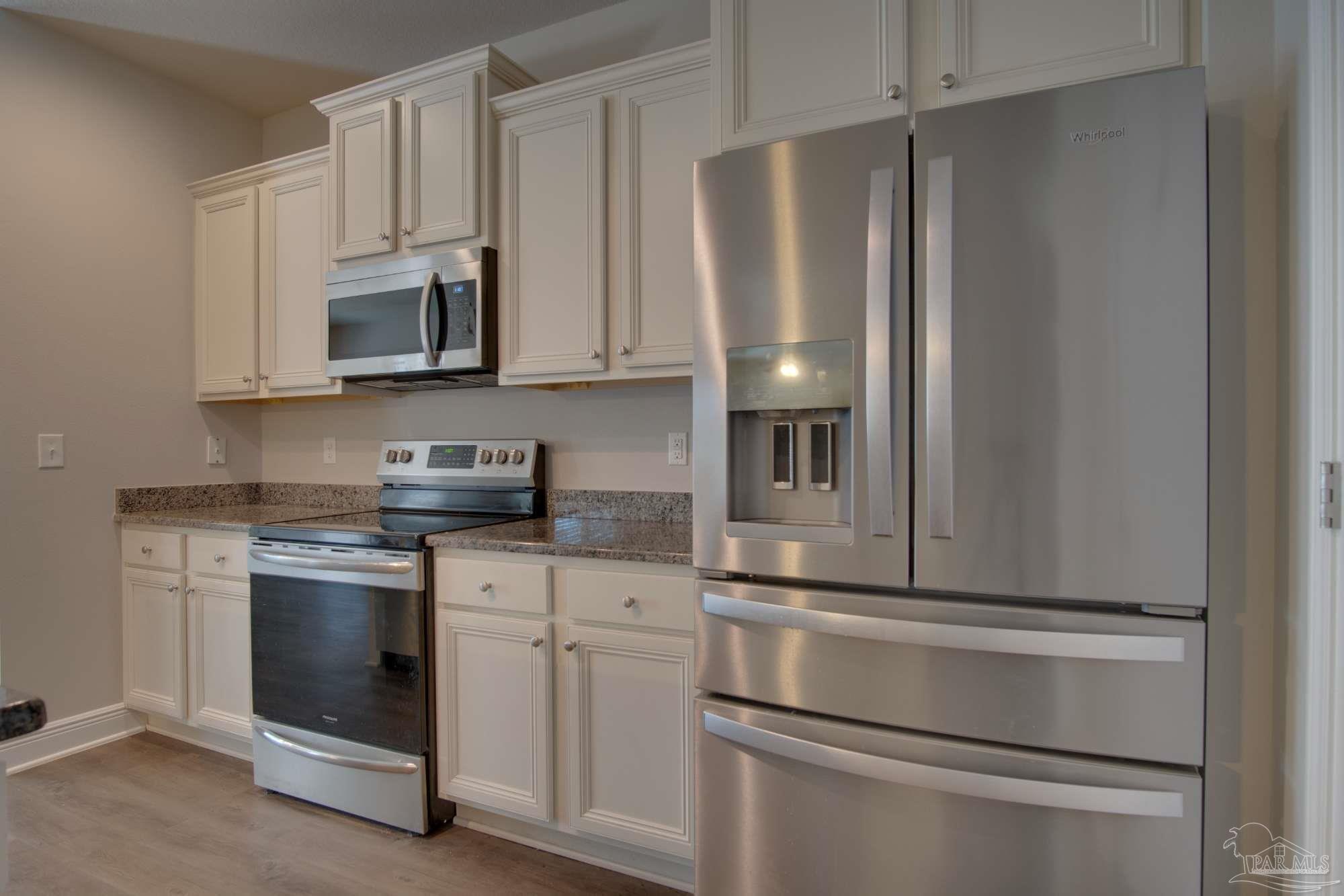 6239 Ladera Trail Pace, FL 32571 - Photo 10 of 27 a kitchen with stainless steel appliances granite countertop white cabinets and refrigerator