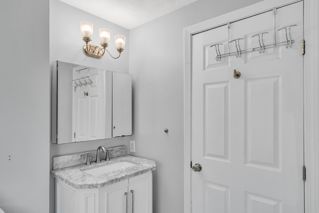 58 MacIntosh Lane, Unit 58 Boxborough, MA 01719 - Photo 14 of 23 a bathroom with a granite countertop sink a mirror and shower