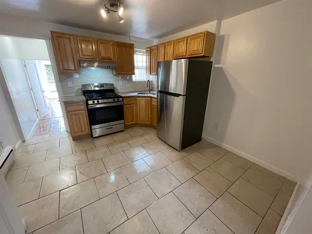 a kitchen with stainless steel appliances a refrigerator and a stove top oven