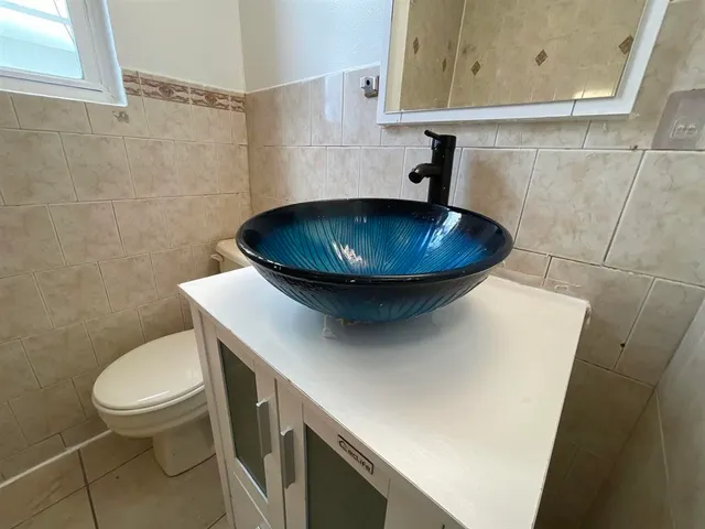 a bathroom with a sink a toilet and a mirror