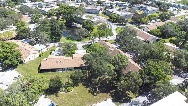an aerial view of a residential houses with yard and trees