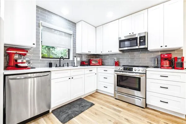 a kitchen with stainless steel appliances white cabinets and white appliances