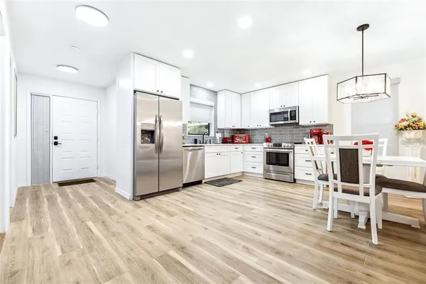 a kitchen with kitchen island a refrigerator and a stove top oven