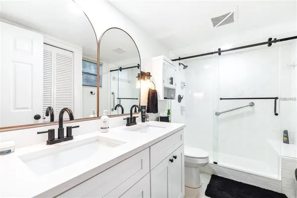 a bathroom with a sink a toilet and a mirror